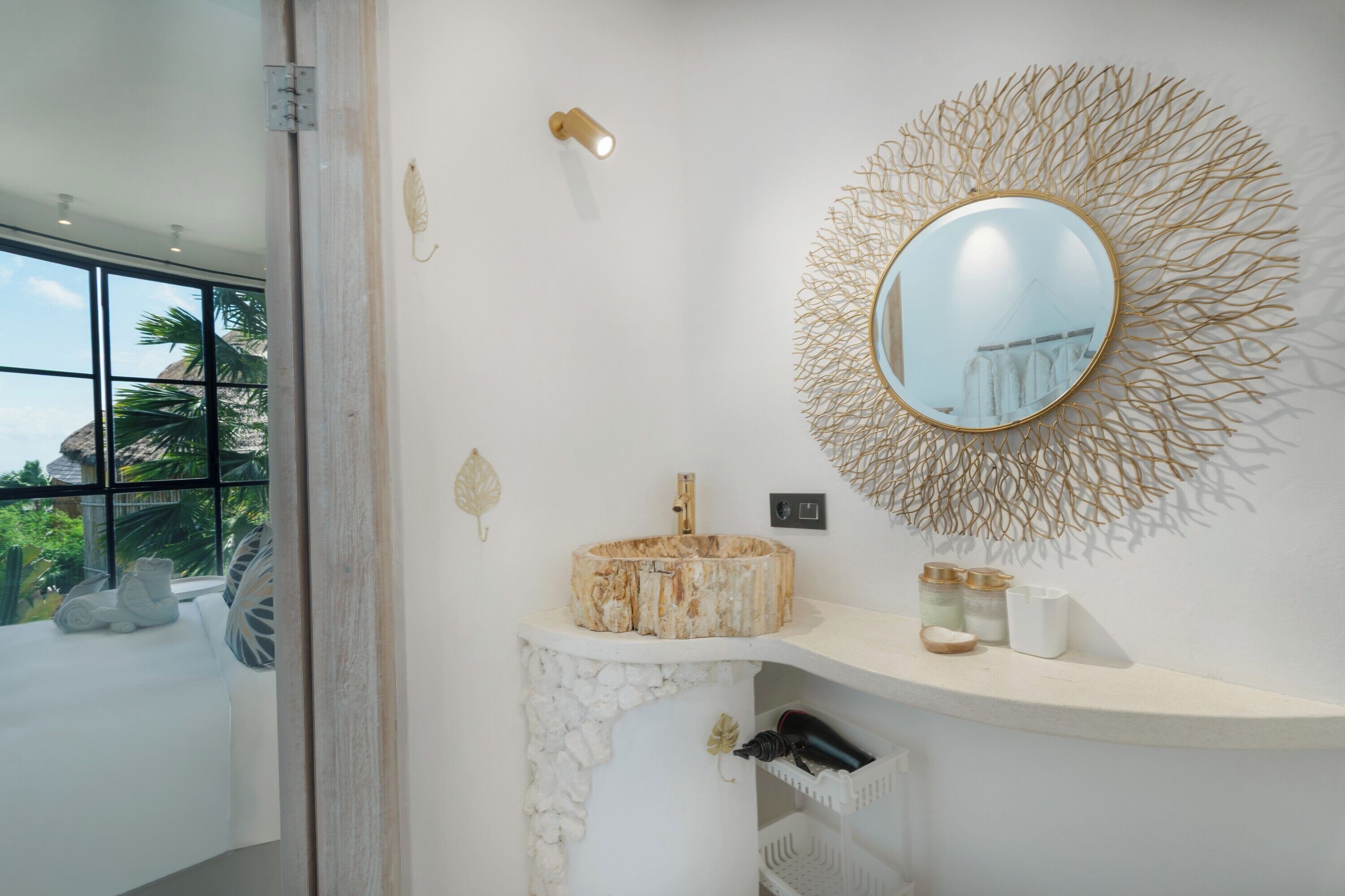 A bathroom with a round mirror, a wooden basin, and a white countertop.
