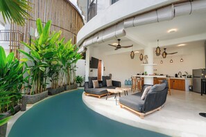 Ein modernes Interieur mit Pool, Sitzgelegenheit, Küche und Essbereich.