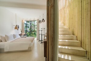 A modern bedroom with a large bed, a desk, and a view of greenery outside. - Hillstone Luxury Villa 8 by Betterplace (Uluwatu)