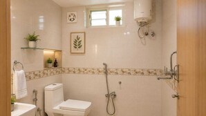 A bathroom with a toilet, sink, shower, and a window.