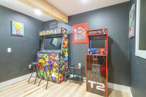 A room with two arcade machines, one labeled 'Arcade Classics' and the other 'Terminator Judgment Day,' along with a small table and stools. - 1 Mi to Mount Snow! Classic Chalet w/ Hot Tub (West Dover)