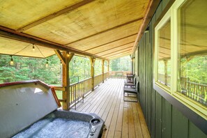 A wooden deck with a hot tub, outdoor seating, and a view of the forest. - 1 Mi to Mount Snow! Classic Chalet w/ Hot Tub (West Dover)