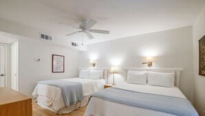 A hotel room with two beds, a ceiling fan, wall-mounted lamps, and a framed map on the wall. - Pawleys Island Golf + Beach Getaway w/ Pool Access (Pawleys Island)