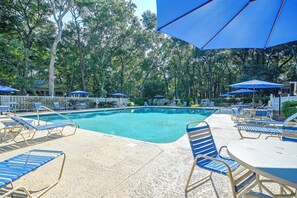 A pool area with lounge chairs and umbrellas, surrounded by trees. - Pawleys Island Golf + Beach Getaway w/ Pool Access (Pawleys Island)