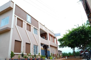 A multi-story building with a sign indicating it is a guest house.