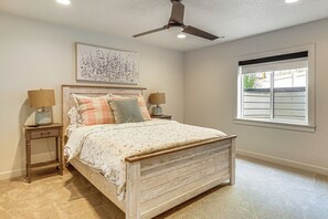 A bedroom with a bed, two bedside tables, a ceiling fan, a window, and a wall-mounted artwork. - Hot Tub, Group Hub, Close to Deer Valley (Heber City)