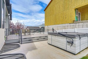 Un espace patio aménagé avec du mobilier d’extérieur, un coin salon couvert et une vue sur les montagnes en arrière-plan.