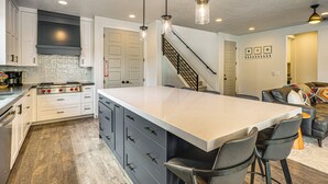 A modern kitchen with a central island, stainless steel appliances, and pendant lighting. - Hot Tub, Group Hub, Close to Deer Valley (Heber City)