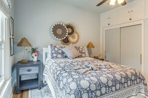 Une chambre à coucher comprenant un lit, des tables de chevet, une armoire et un élément décoratif mural.