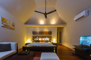 A modern bedroom with a bed, bedside tables, a ceiling fan, and an air conditioning unit. - Veligandu Island Resort & Spa (Veligandu Island)