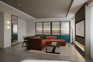 Una sala moderna con un sofá modular, una mesa de centro y un amplio ventanal con persianas.