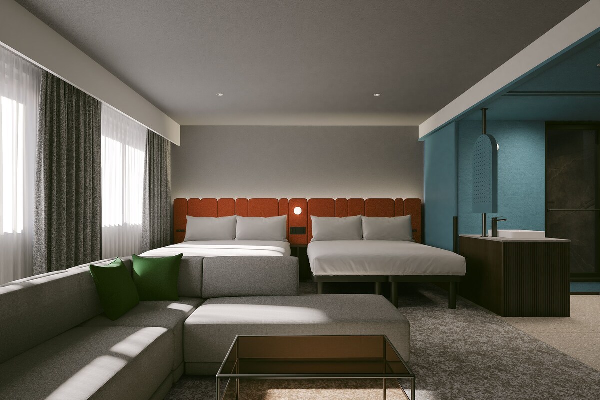 Una habitación de hotel moderna con una cama, un sofá, una mesita y un baño.