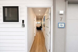 Un pasillo con una puerta marcada con el número 7 y un letrero que dice 'Coast a'While'.