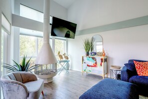 Ein modernes Wohnzimmer mit Kamin, Sitzgelegenheiten und Fernseher.