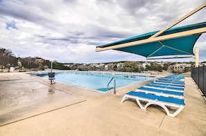Ein Schwimmbecken mit Liegestühlen und Sonnenschutz.
