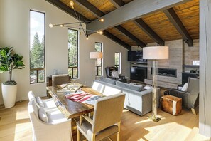 A spacious living area with a wooden ceiling, a fireplace, and a large window offering a view of trees. - Stunning Lake & Mtn Views! CB/Incline Village Home (Crystal Bay)