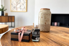 A wooden table with a gift box and a bottle of sauce.