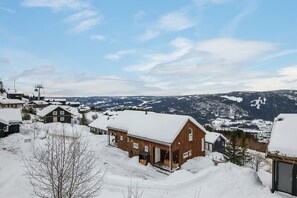A snowy village with wooden houses, a ski lift, and a mountain backdrop. - Hafjell Retreat - Kaldsvekroken Ski Cabin (Øyer)