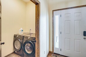 A laundry room with two Samsung washing machines, a bottle of detergent, and a door with a security lock. - Mtn-View Deck! Remote South Park Retreat (Hartsel)
