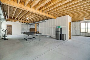 A spacious room with a ping pong table, a refrigerator, and a door leading to another area. - Mtn-View Deck! Remote South Park Retreat (Hartsel)