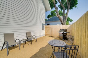 A backyard with a barbecue grill, two chairs, and a table. - 1 Mi to UM Campus! Newly Built Apt w/ Side Yard (Missoula)