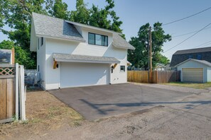 A two-story house with a garage, surrounded by a wooden fence and trees. - 1 Mi to UM Campus! Newly Built Apt w/ Side Yard (Missoula)