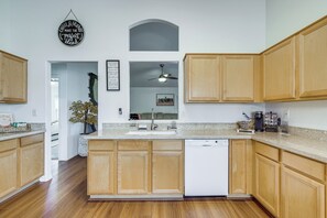 A modern kitchen with wooden cabinets, a Bosch dishwasher, and a coffee maker. - 5 Mi to Stadiums! Quiet & Sun-Soaked Peoria Oasis (Peoria)