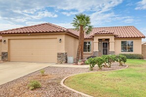A residential house with a garage, a stone accent wall, a palm tree, and a landscaped garden. - 5 Mi to Stadiums! Quiet & Sun-Soaked Peoria Oasis (Peoria)