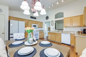 A modern kitchen with wooden cabinets, a white refrigerator, a microwave, and a dishwasher. - 5 Mi to Stadiums! Quiet & Sun-Soaked Peoria Oasis (Peoria)