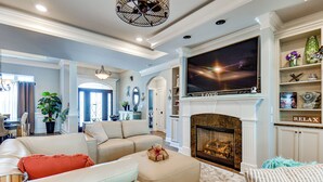 A spacious living room with a fireplace, a large flat-screen TV, and a comfortable seating area. - Sun, Fun & Soak: Stunning Myrtle Beach Escape! (Myrtle Beach)