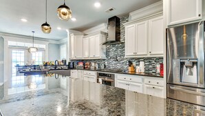 A spacious kitchen with a large island, stainless steel appliances, and a modern tile backsplash. - Sun, Fun & Soak: Stunning Myrtle Beach Escape! (Myrtle Beach)