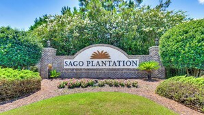 A sign for Sago Plantation with a brick wall and greenery. - Sun, Fun & Soak: Stunning Myrtle Beach Escape! (Myrtle Beach)