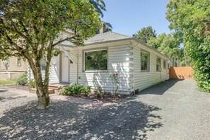 Casa móvel térrea com entrada por um caminho de brita e um pequeno jardim com diversas plantas.
