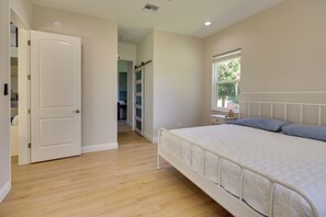 A bedroom with a bed, a window, and a door leading to another room. - Private Dock & Patio! Lake June Waterfront Home (Lake Placid)