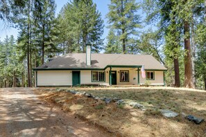 A single-story house with a gabled roof, a front porch, and a flag. - Horse-Friendly Escape w/ 400 Mi of Trails (Georgetown)