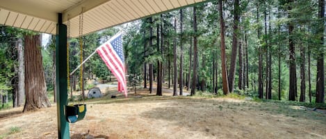A covered outdoor area with a swing set and an American flag.