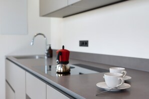 A modern kitchen with a stainless steel countertop, a kettle, and two white cups on saucers. - Apartment 2nd Floor - Villa Aulank (Ritten)