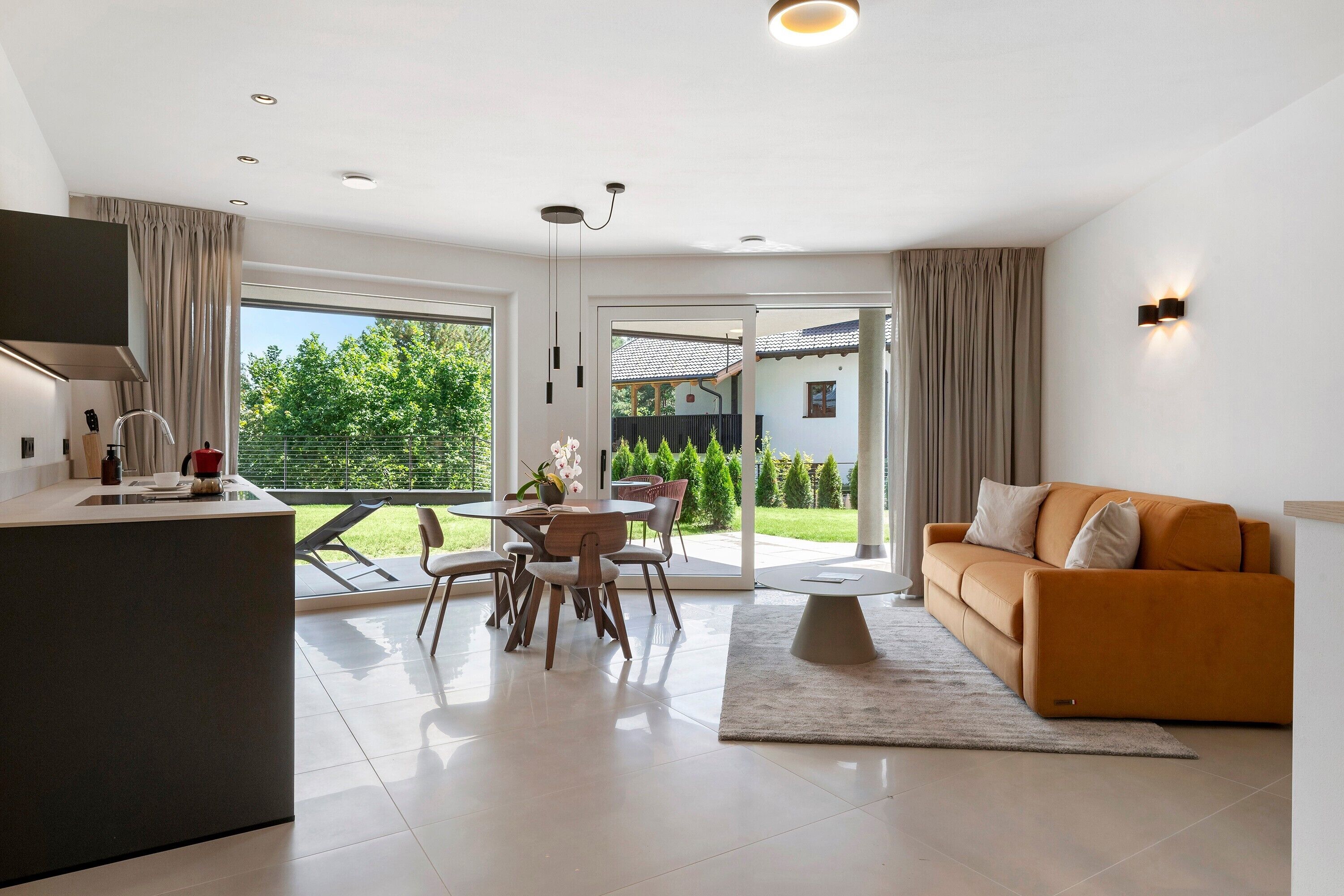 A modern living space with a kitchen, dining area, and a sofa.