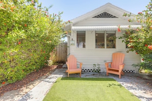 A house with a front yard, two wooden chairs, and a small lawn. - Walk to Dtwn! Home 2 Mi to Lake Worth Beach Park (Lake Worth Beach)