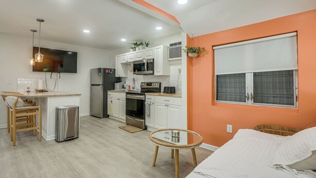 A compact kitchen with modern appliances, a dining area with a table, and a living space with a sofa. - Walk to Dtwn! Home 2 Mi to Lake Worth Beach Park (Lake Worth Beach)