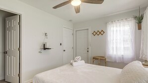 A bedroom with a bed, a ceiling fan, a window with sheer curtains, and a door. - Walk to Dtwn! Home 2 Mi to Lake Worth Beach Park (Lake Worth Beach)