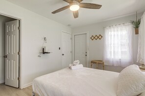 A bedroom with a bed, a ceiling fan, a window with sheer curtains, and a door. - Walk to Dtwn! Home 2 Mi to Lake Worth Beach Park (Lake Worth Beach)