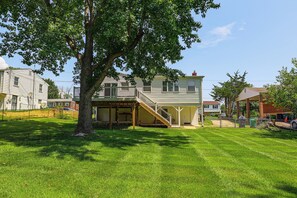 A two-story house with a covered porch and a staircase leading to the upper level. - Family Home w/ Fenced Backyard, 16 Mi to DC! (Clinton)