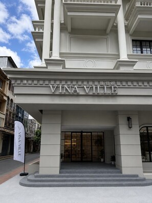 A entrada da Vina Ville, com uma fachada imponente, colunas grandes e um acesso destacado.