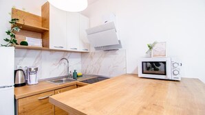 A modern kitchen with a wooden countertop, a built-in microwave, and a stainless steel sink.