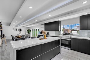 A modern kitchen with a large island, black cabinetry, and stainless steel appliances. - Miami Resort Villa with Jacuzzi & Sauna (Miami)