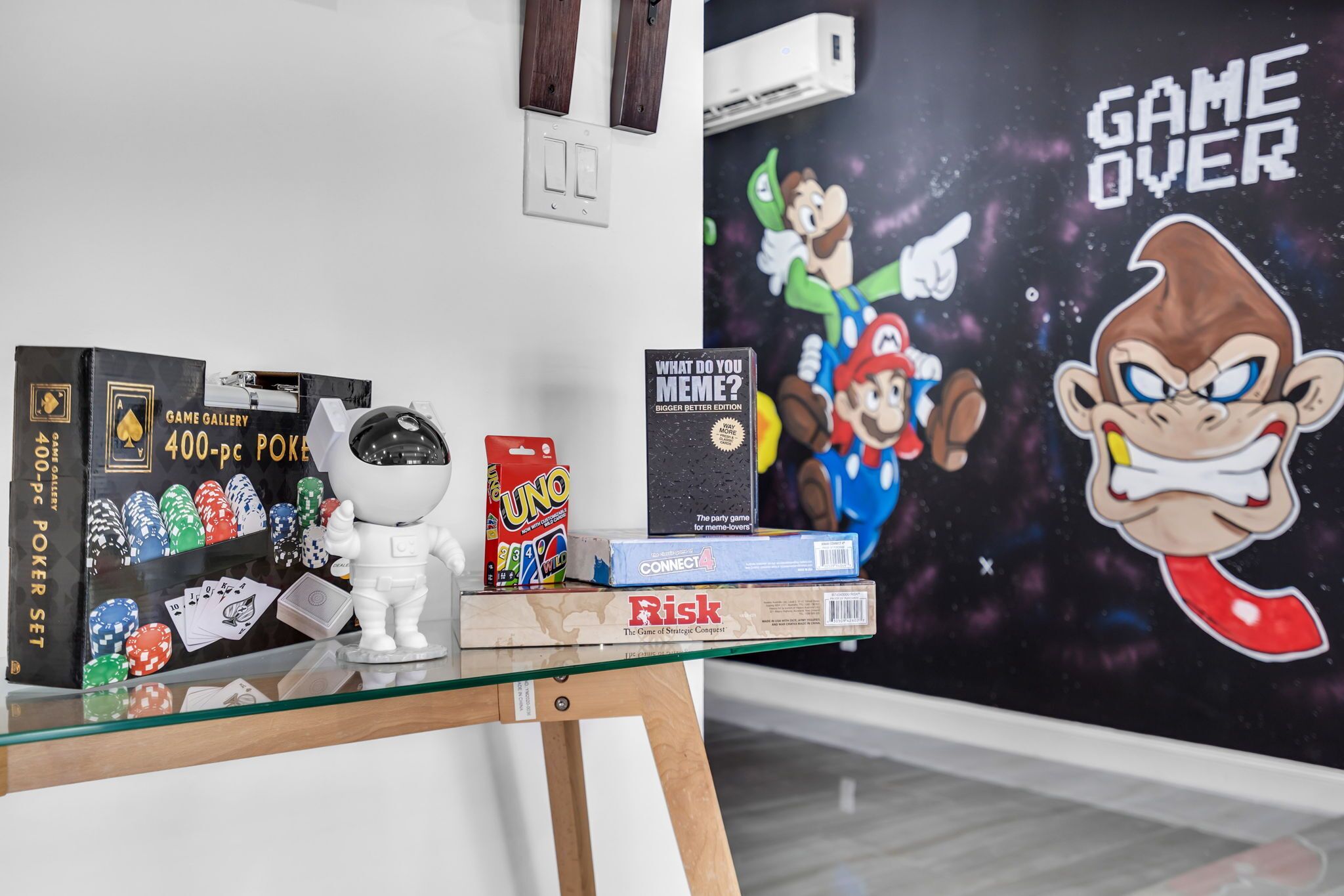 A glass display table with various board games and a wall art piece.