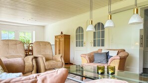 A living room with leather armchairs, a glass coffee table, and pendant lights. - Spacious, detached villa for 12 people near Winterberg (Grönebach)