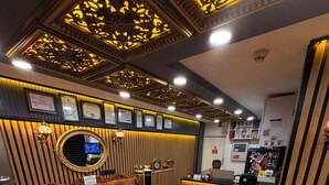 A reception area with a sofa, a chair, a reception desk, and a fire extinguisher.