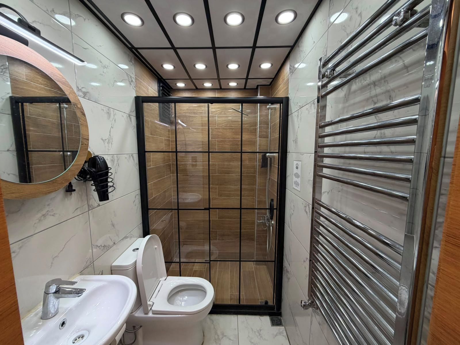 Un baño moderno con inodoro, lavabo y espejo.